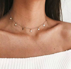 Woman wearing gold star charm choker necklace, celestial dainty jewelry for layering