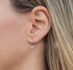 Woman wearing evil eye Huggie earrings