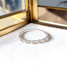 Load image into Gallery viewer, Silver ring with small flowers on a white surface with a gold jewelry box in the background
