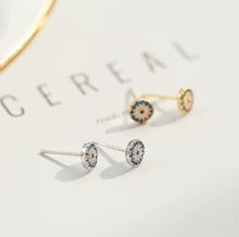 Load image into Gallery viewer, Sterling silver and gold-plated sterling silver evil eye stud earrings with blue and white cubic zirconia stones, protective talisman jewellery symbolizing luck and protection, displayed on a white background.
