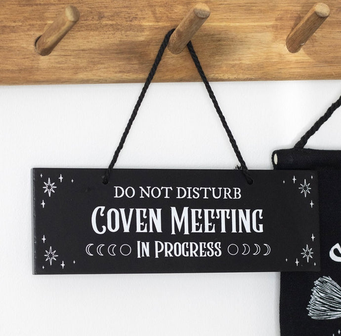 Witchy décor scene featuring Coven Meeting in Progress sign on wall
